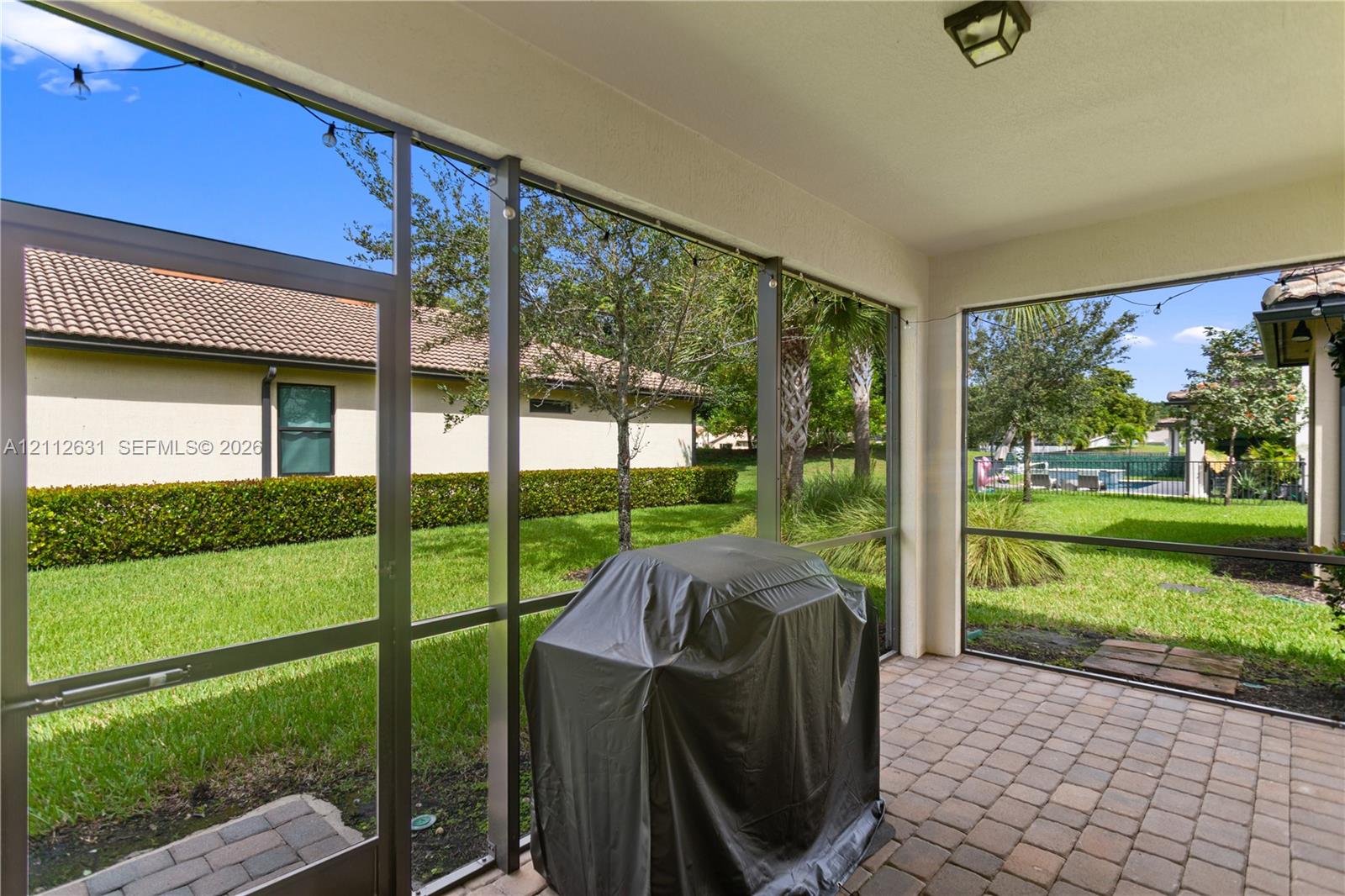 Screened-in lanai featuring paver flooring, a covered ceiling with recessed lighting, and metal framing