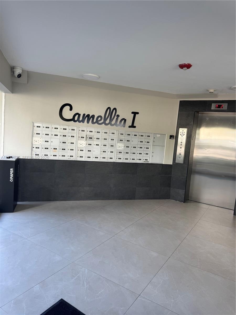 Lobby featuring large-format ceramic floor tiling, stainless steel elevator, integrated mailbox bank, and decorative stone wall cladding Lobby featuring large-format ceramic floor tiling, stainless steel elevator, integrated mailbox bank, and decorative stone wall cladding