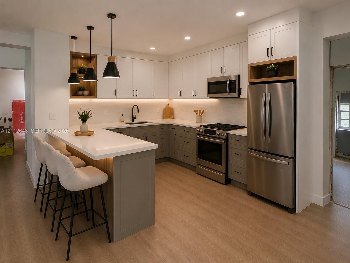 Kitchen featuring two-tone shaker-style cabinetry, quartz countertops, stainless steel appliances, wood-finish flooring, and pendant lighting Kitchen featuring two-tone shaker-style cabinetry, quartz countertops, stainless steel appliances, wood-finish flooring, and pendant lighting