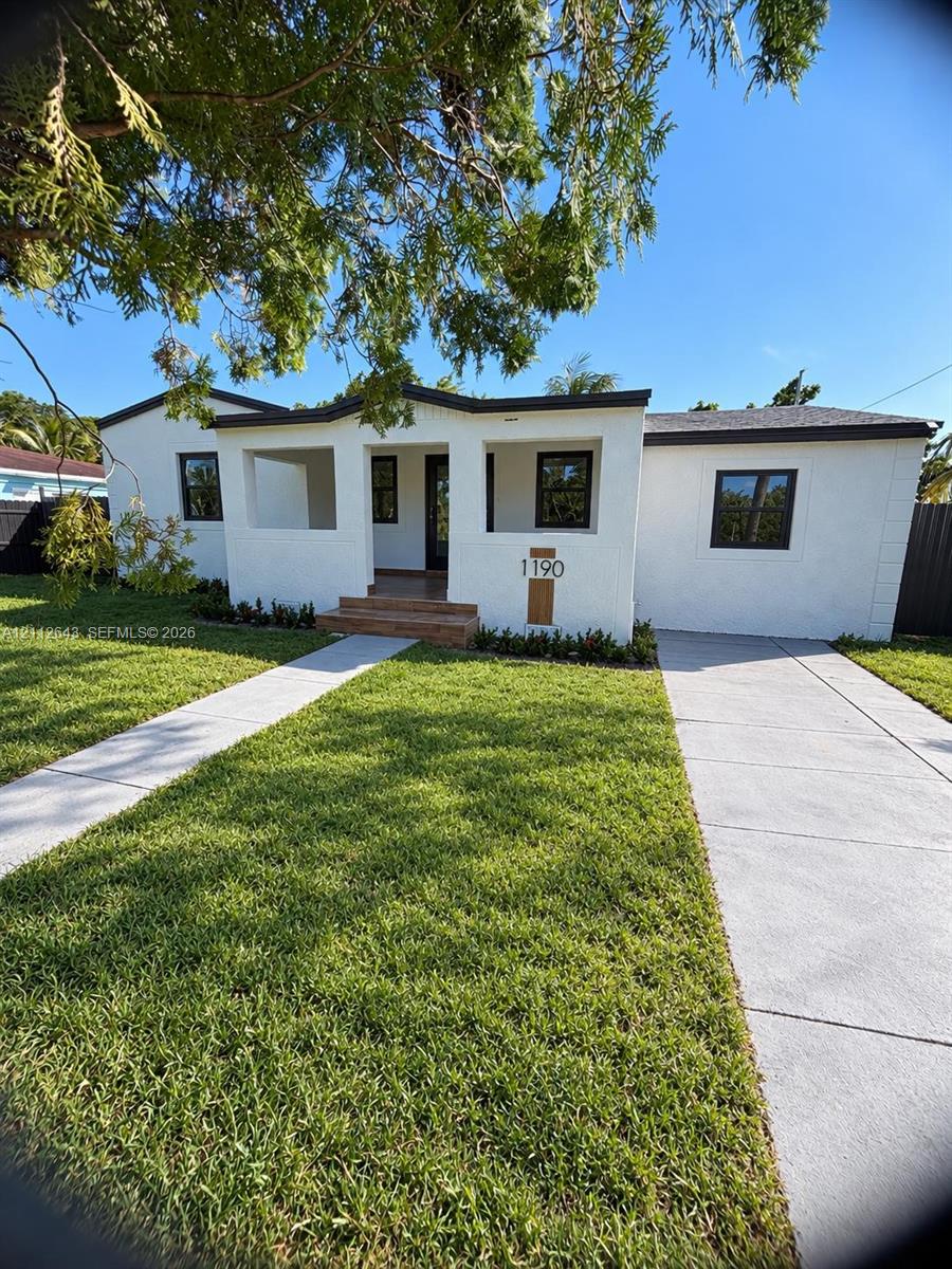 Single-story exterior featuring white stucco finish, a recessed covered entryway, tile-accented steps, and a paved concrete driveway Single-story exterior featuring white stucco finish, a recessed covered entryway, tile-accented steps, and a paved concrete driveway