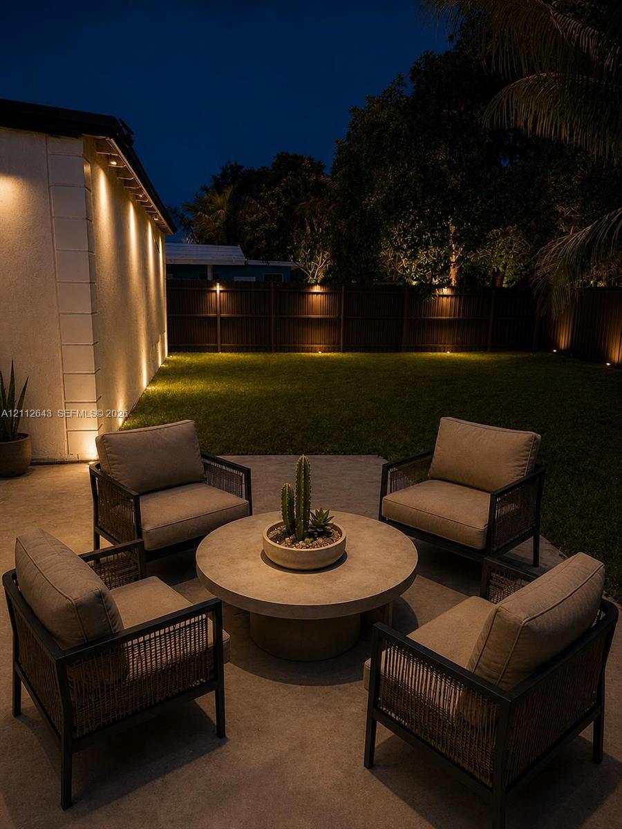 Concrete patio featuring recessed wall lighting and a perimeter privacy fence Concrete patio featuring recessed wall lighting and a perimeter privacy fence