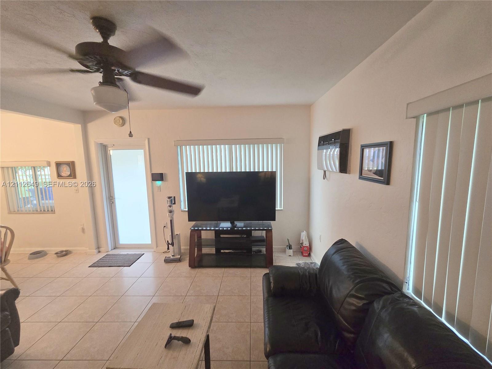 Ceramic tile flooring, ceiling fan with integrated lighting, and vertical window blinds Ceramic tile flooring, ceiling fan with integrated lighting, and vertical window blinds