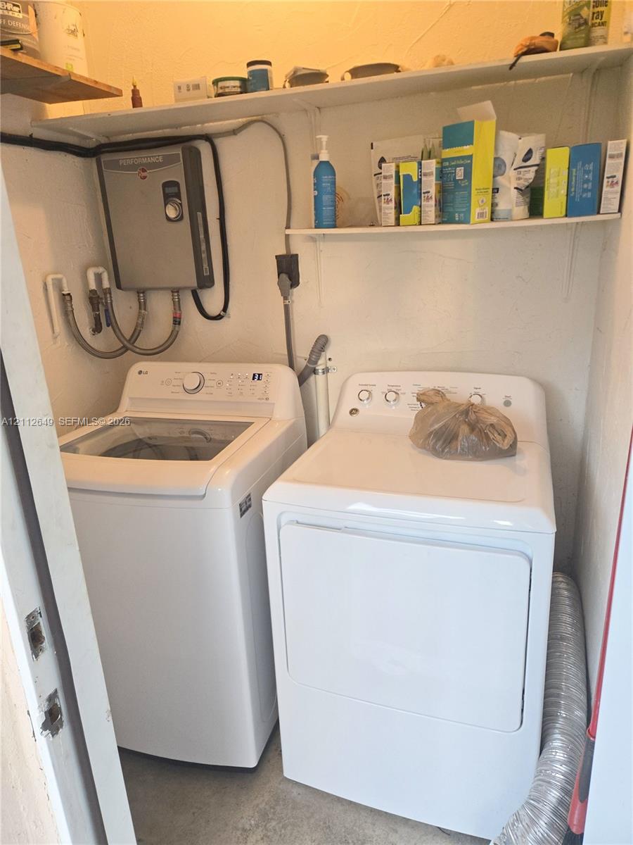 Laundry area featuring wall-mounted shelving and a tankless water heater