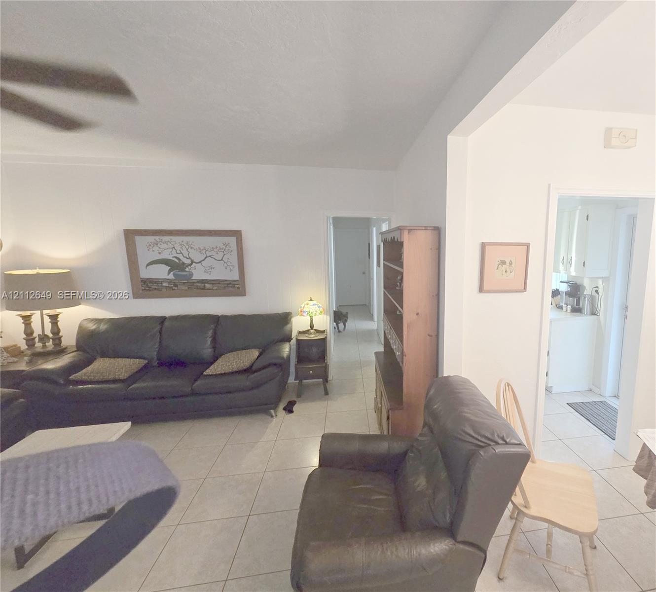 Light-toned ceramic tile flooring, ceiling fan with integrated lighting, and neutral wall finishes Light-toned ceramic tile flooring, ceiling fan with integrated lighting, and neutral wall finishes