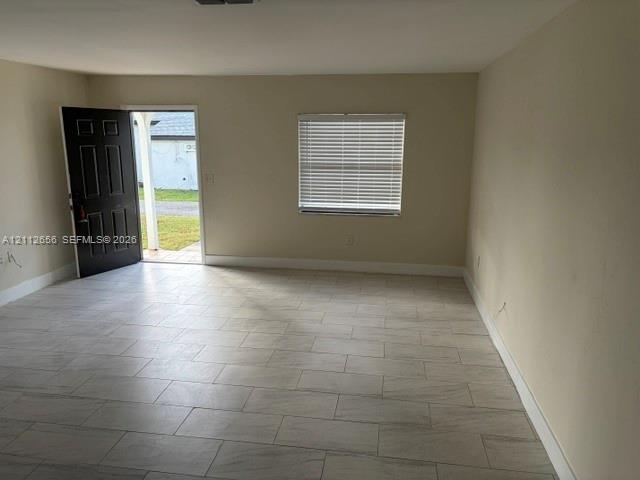 Neutral-toned walls, tile flooring, and a window with horizontal blinds