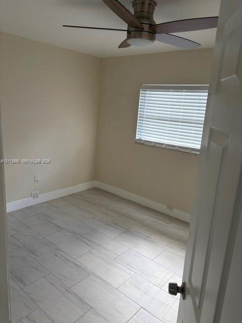 Neutral-toned interior room featuring wood-finish tile flooring, a multi-blade ceiling fan with integrated lighting, and a window equipped with horizontal blinds
