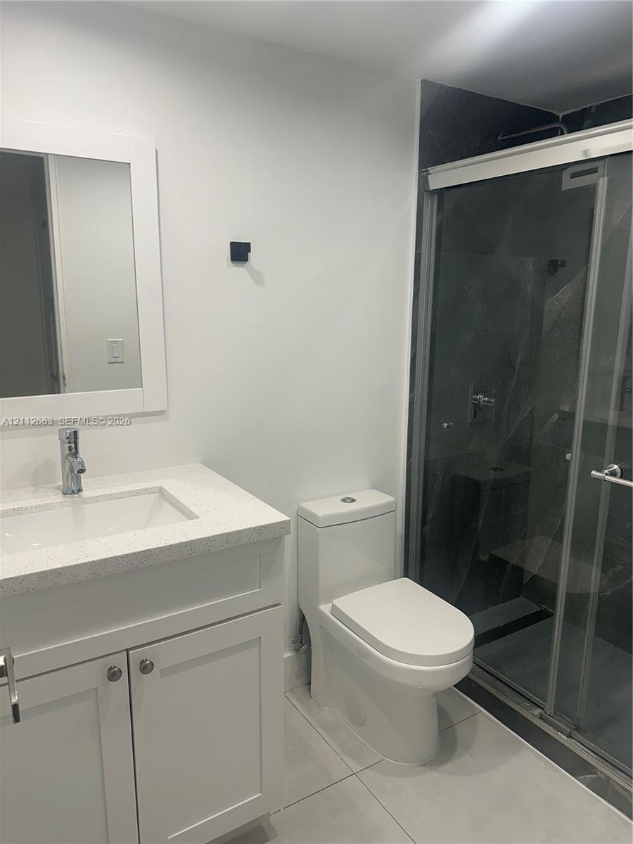 Bathroom featuring a vanity with a white composite countertop, integrated rectangular sink, and polished chrome faucet