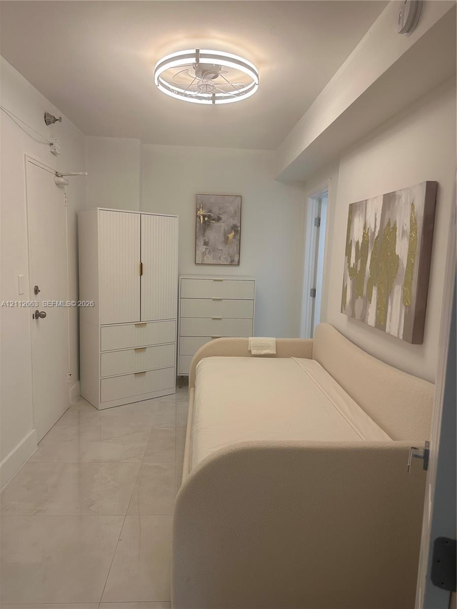 Room featuring large-format tile flooring and a circular flush-mount LED ceiling light fixture