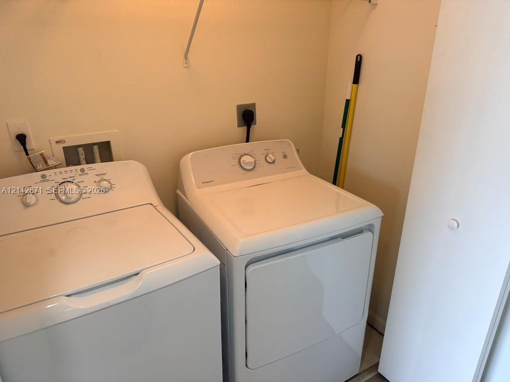 Laundry area featuring dedicated water and electrical hookups with overhead shelving