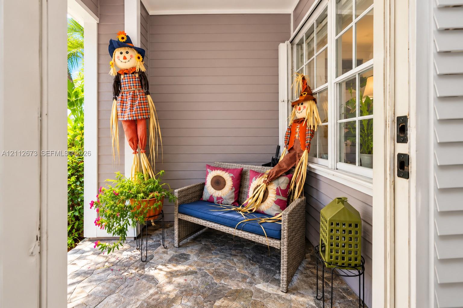 Covered entryway featuring natural stone flooring, horizontal lap siding, and multi-pane grid windows Covered entryway featuring natural stone flooring, horizontal lap siding, and multi-pane grid windows