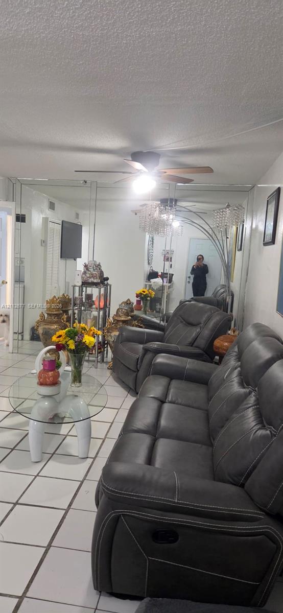 Floor-to-ceiling wall mirrors, white ceramic tile flooring, and a ceiling-mounted fan with integrated lighting