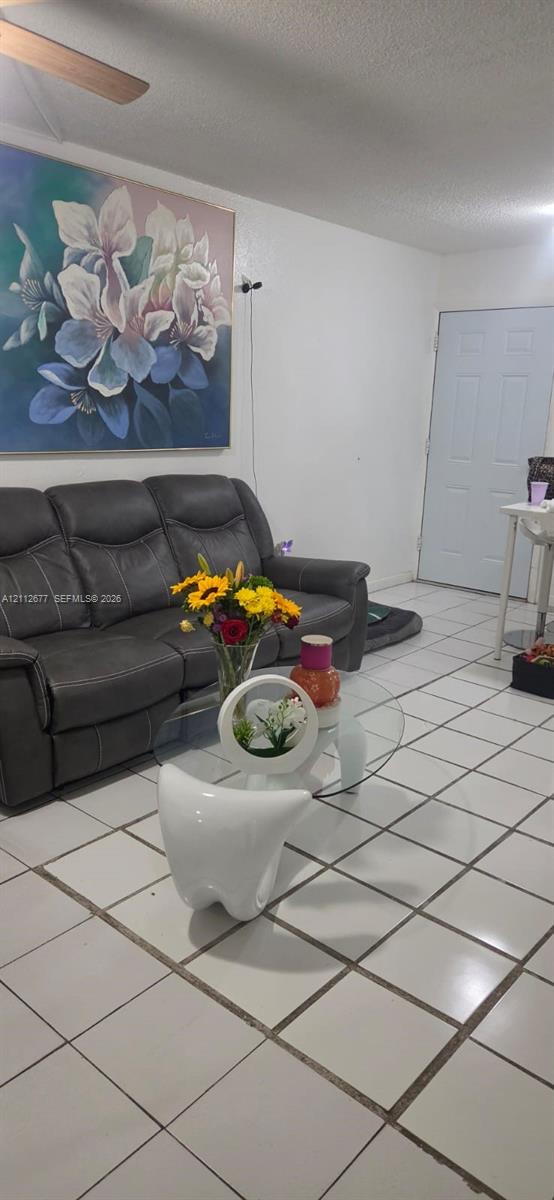 Ceramic tile flooring throughout with a six-panel entry door and ceiling-mounted fan