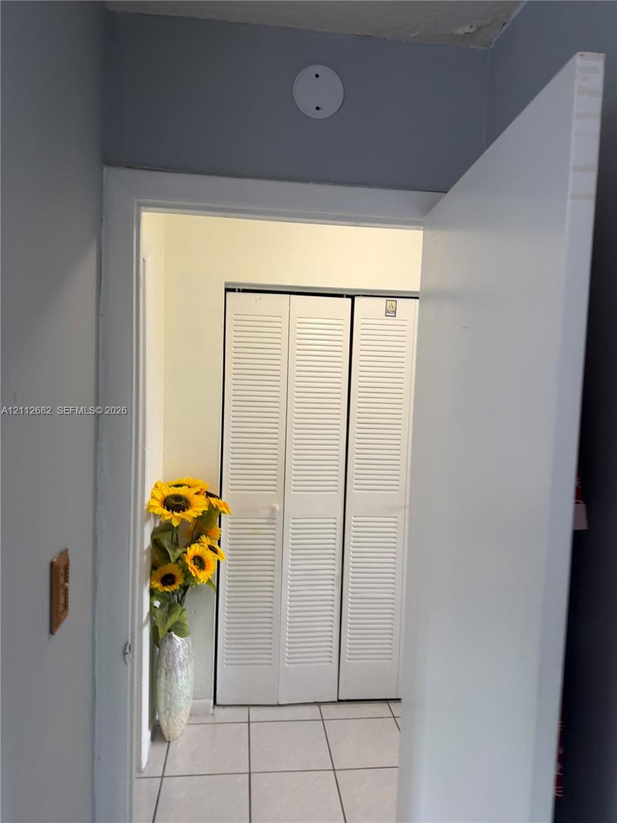 White louvered bifold closet doors and tiled flooring