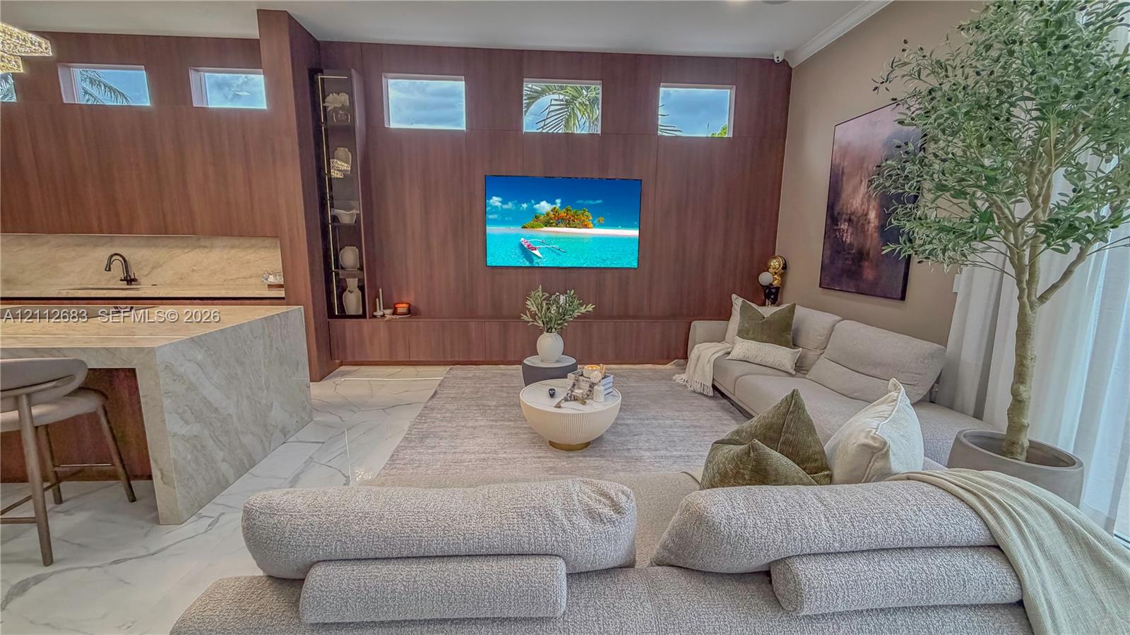 Floor-to-ceiling wood paneling with integrated shelving, stone waterfall island, high-contrast stone flooring, and clerestory windows