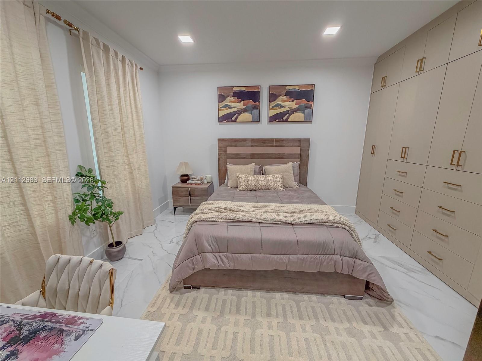 Floor-to-ceiling built-in cabinetry with integrated drawers and brass-tone hardware, stone-finish flooring, and recessed lighting
