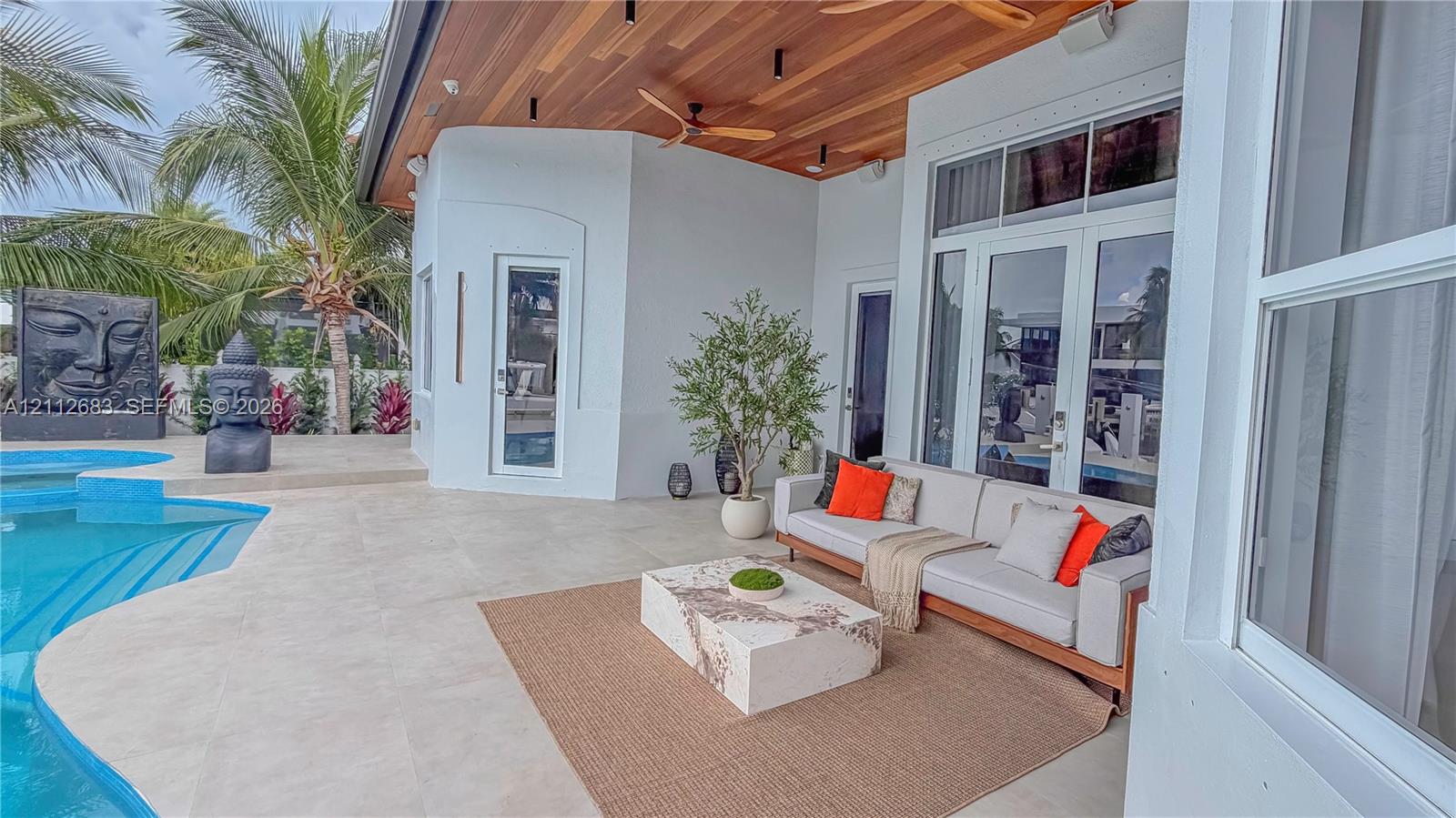 Covered patio featuring a wood-plank ceiling with integrated recessed lighting and ceiling fans, large-format tile flooring, and a swimming pool