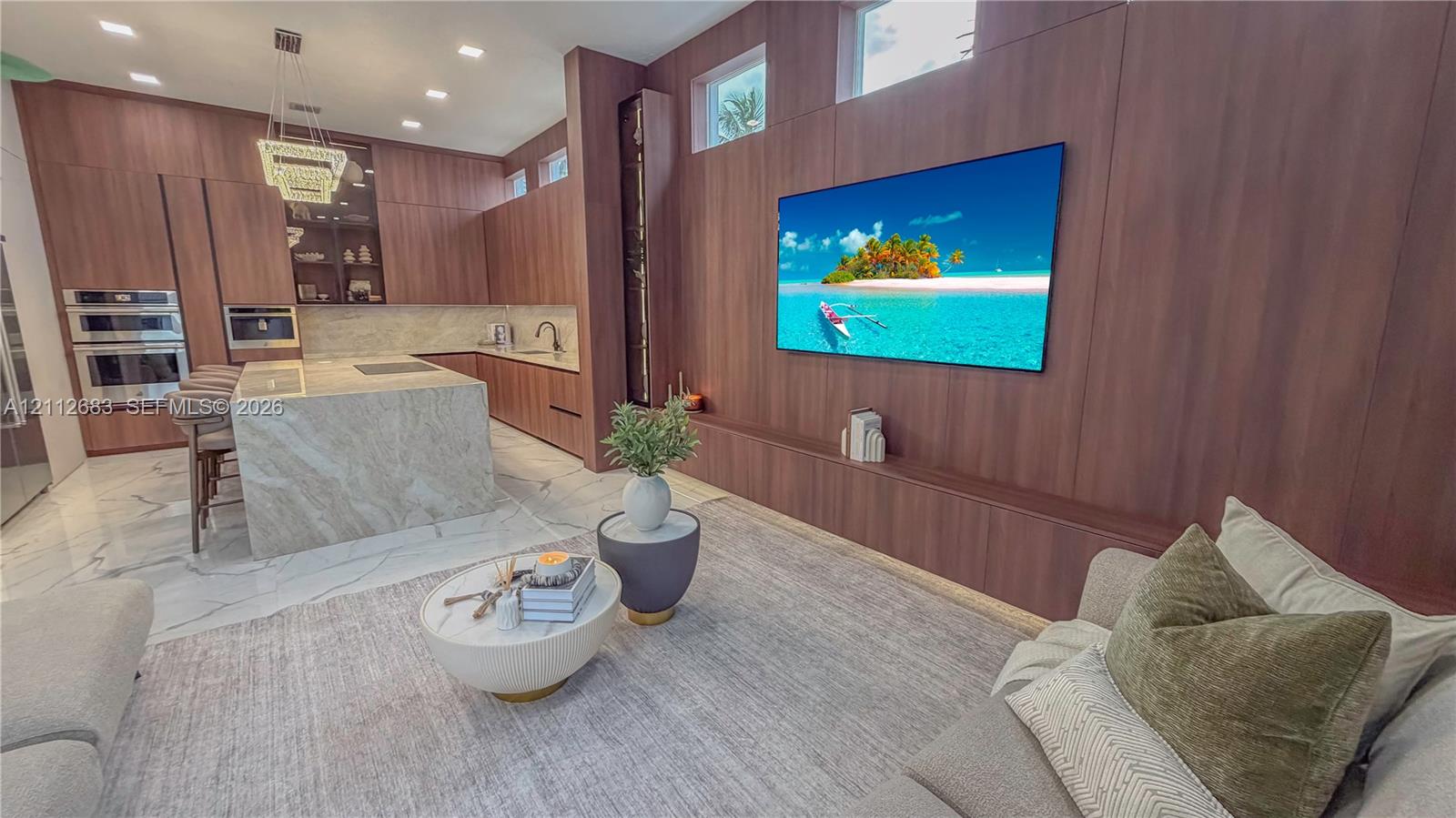 Modern kitchen featuring full-height wood-panel cabinetry, a waterfall-edge stone island, built-in double wall ovens, integrated ceiling lighting, and clerestory windows