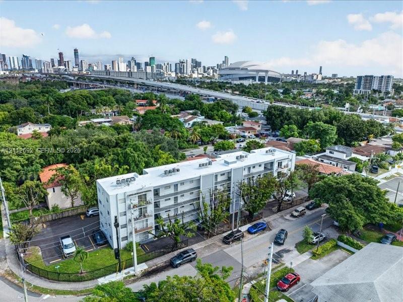 Multi-story residential building featuring exterior corridors, private balconies, on-site paved parking, and established perimeter landscaping