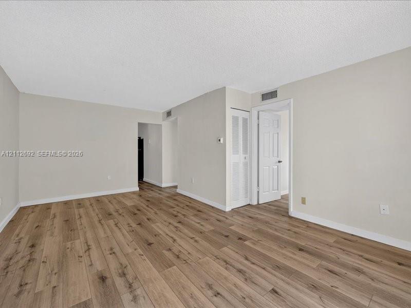 Interior space featuring wood-finish flooring, neutral wall tones, and a six-panel interior door