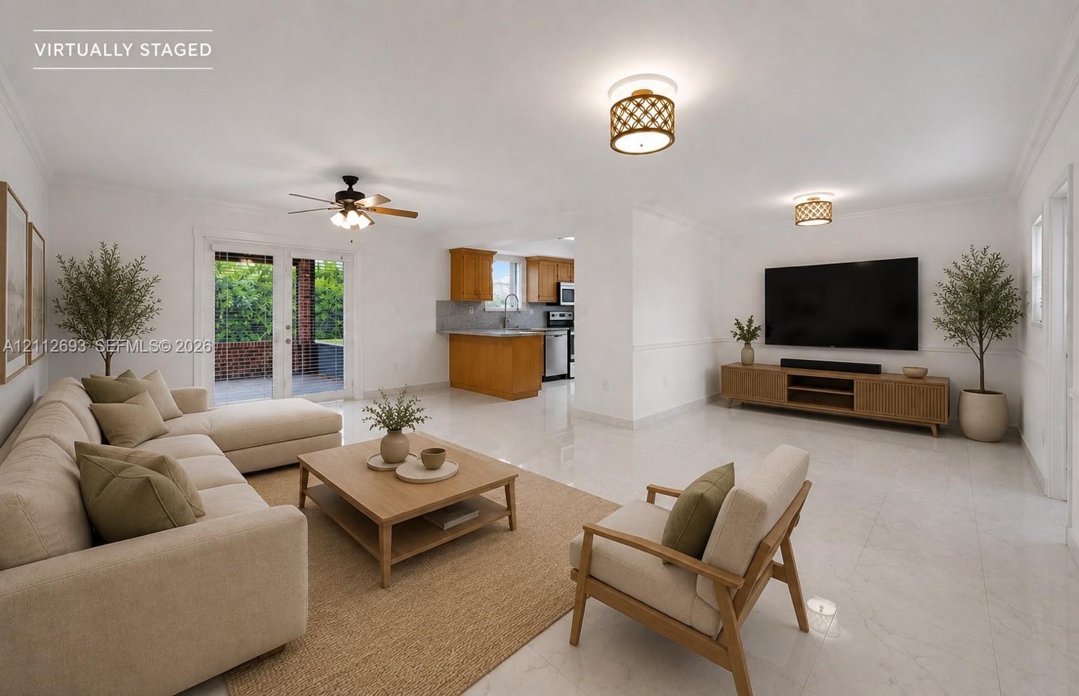 Open-concept interior featuring light-toned tile flooring, recessed crown molding, ceiling fan with light kit, decorative drum lighting fixtures, and double glass doors