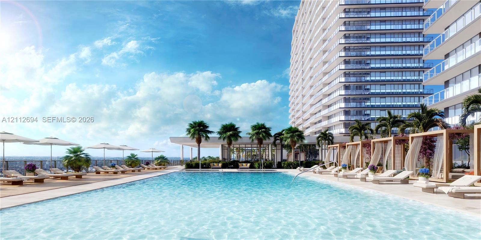 Rooftop swimming pool featuring a spacious sun deck, integrated poolside cabanas, and manicured palm tree landscaping