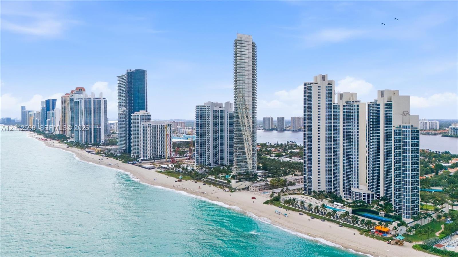 Aerial perspective of coastal high-rise development featuring direct beach access, proximity to the Atlantic Ocean, and expansive shoreline exposure