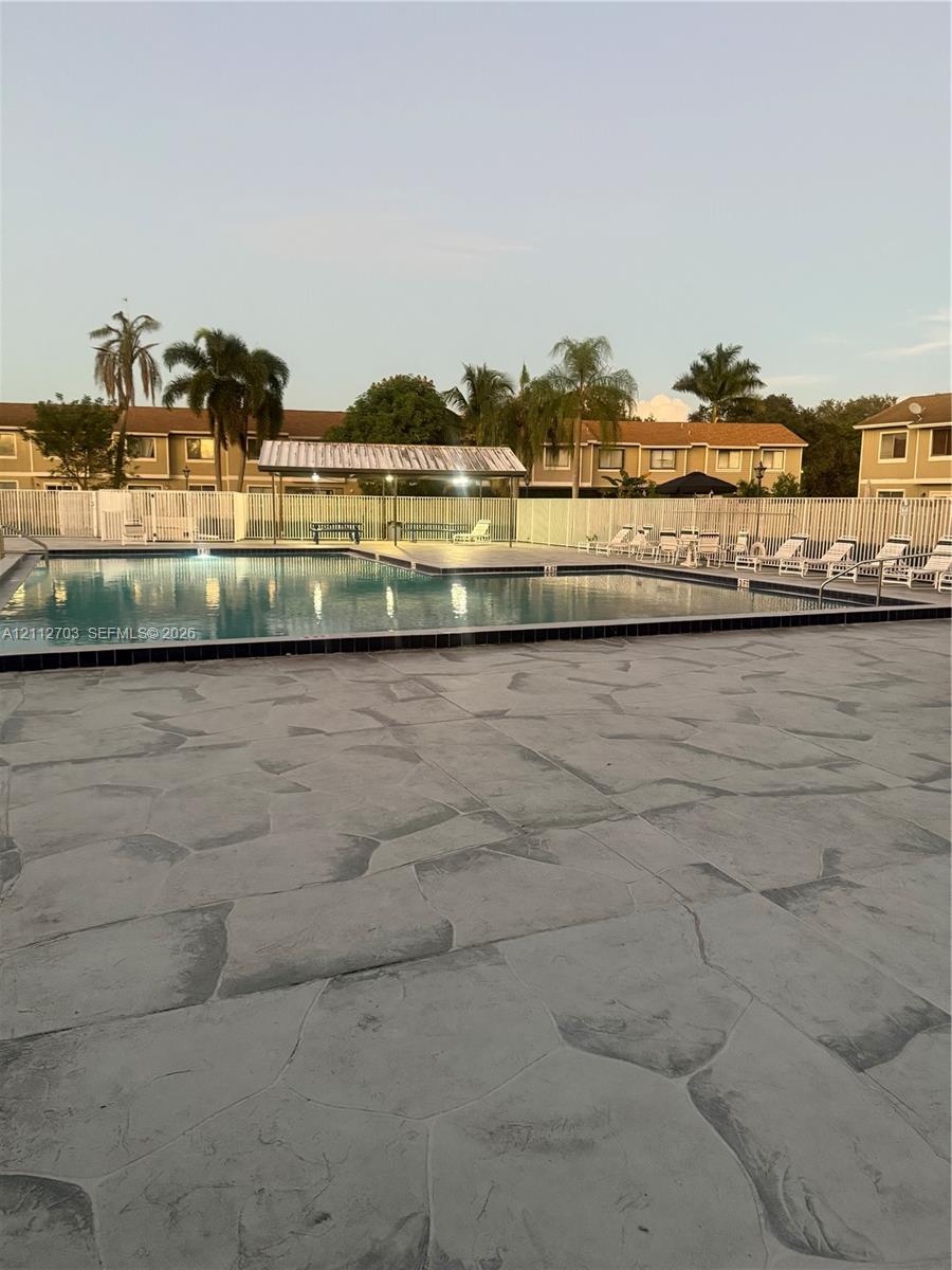 Swimming pool with stamped concrete deck, metal-roofed cabana, and perimeter fencing Swimming pool with stamped concrete deck, metal-roofed cabana, and perimeter fencing