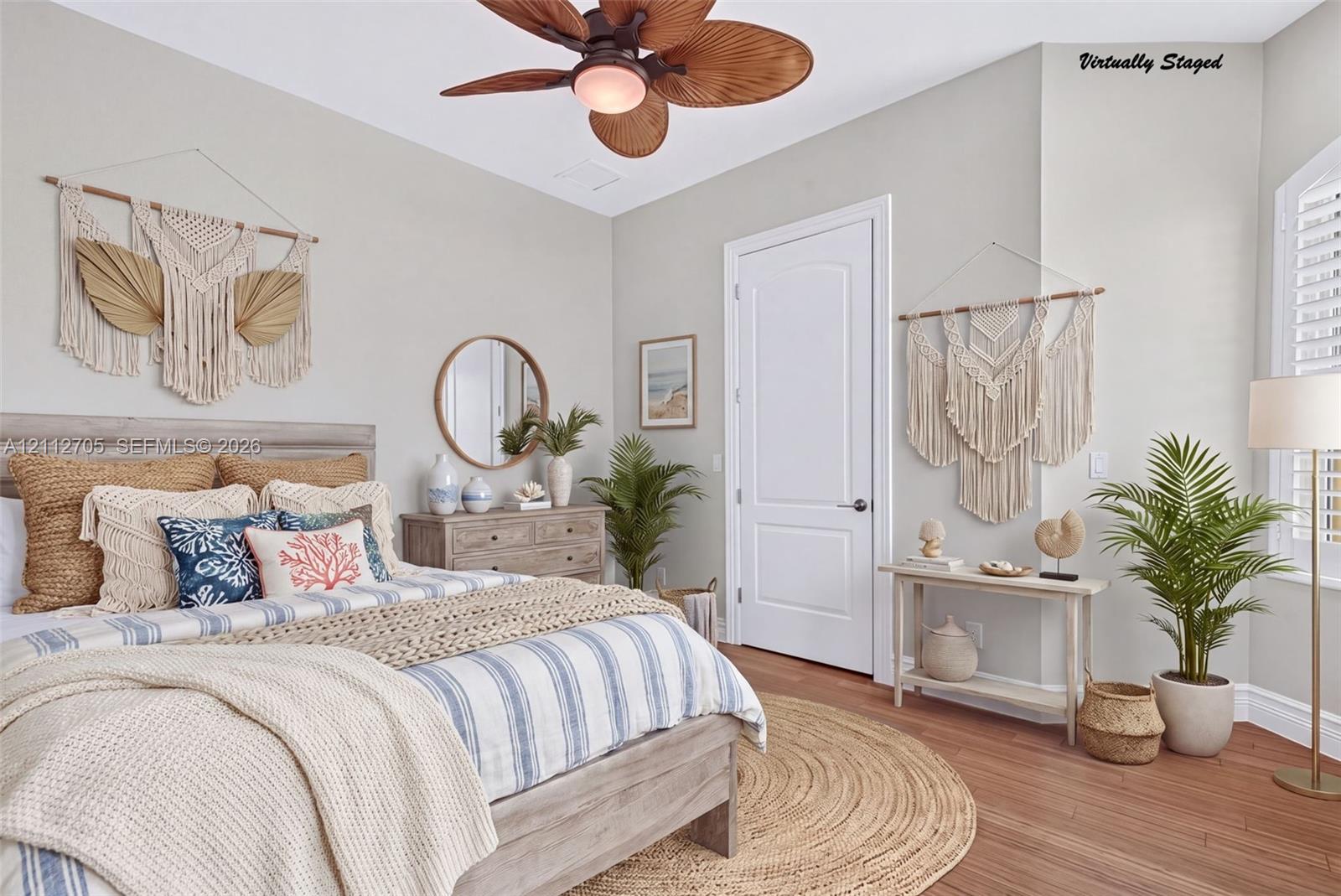 VIRTUALLY STAGED Room featuring wood-finish flooring, a multi-blade ceiling fan with integrated lighting, a solid-core interior door, and window shutters