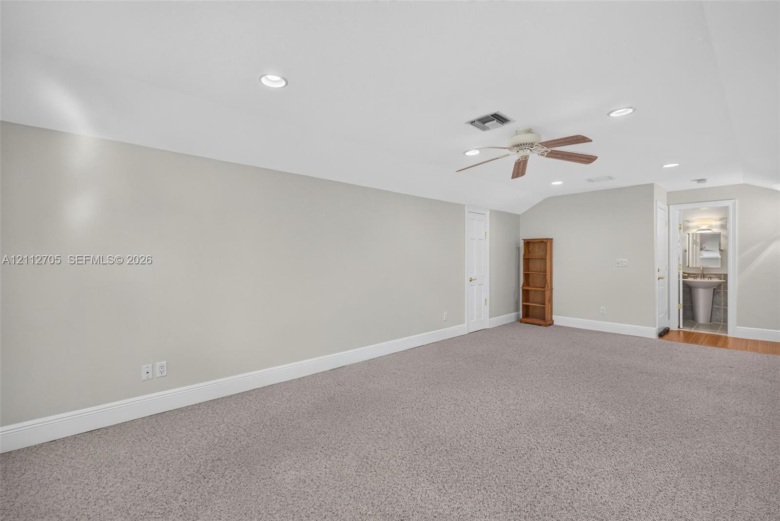 Neutral-toned interior featuring wall-to-wall carpeting, recessed lighting, and a ceiling fan with integrated light fixture