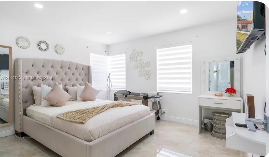 Bright interior featuring light-toned tile flooring, recessed lighting, and dual-layered window shades