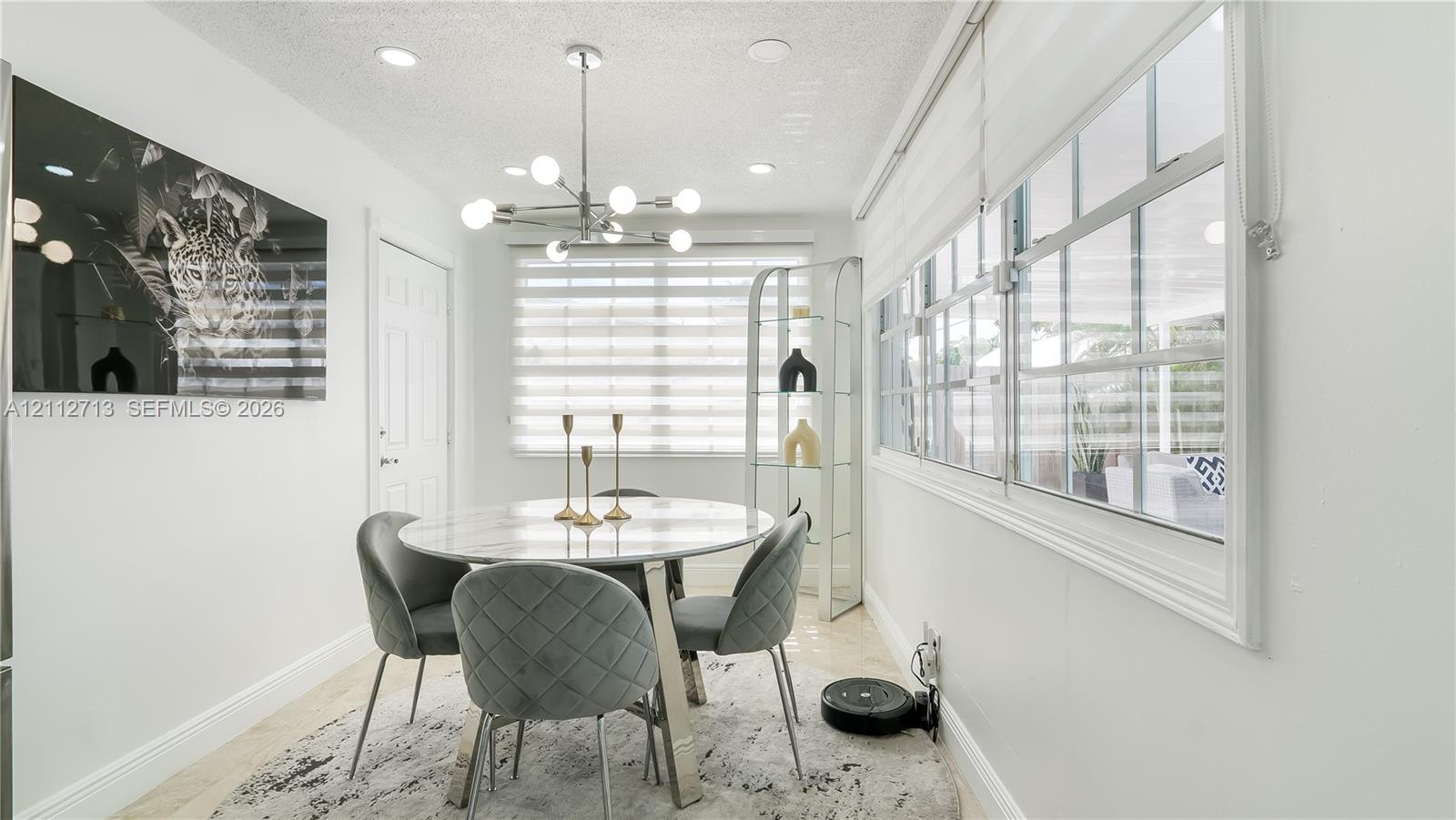 Dining area featuring recessed lighting, a modern multi-bulb chandelier, large windows with horizontal blinds, and tile flooring