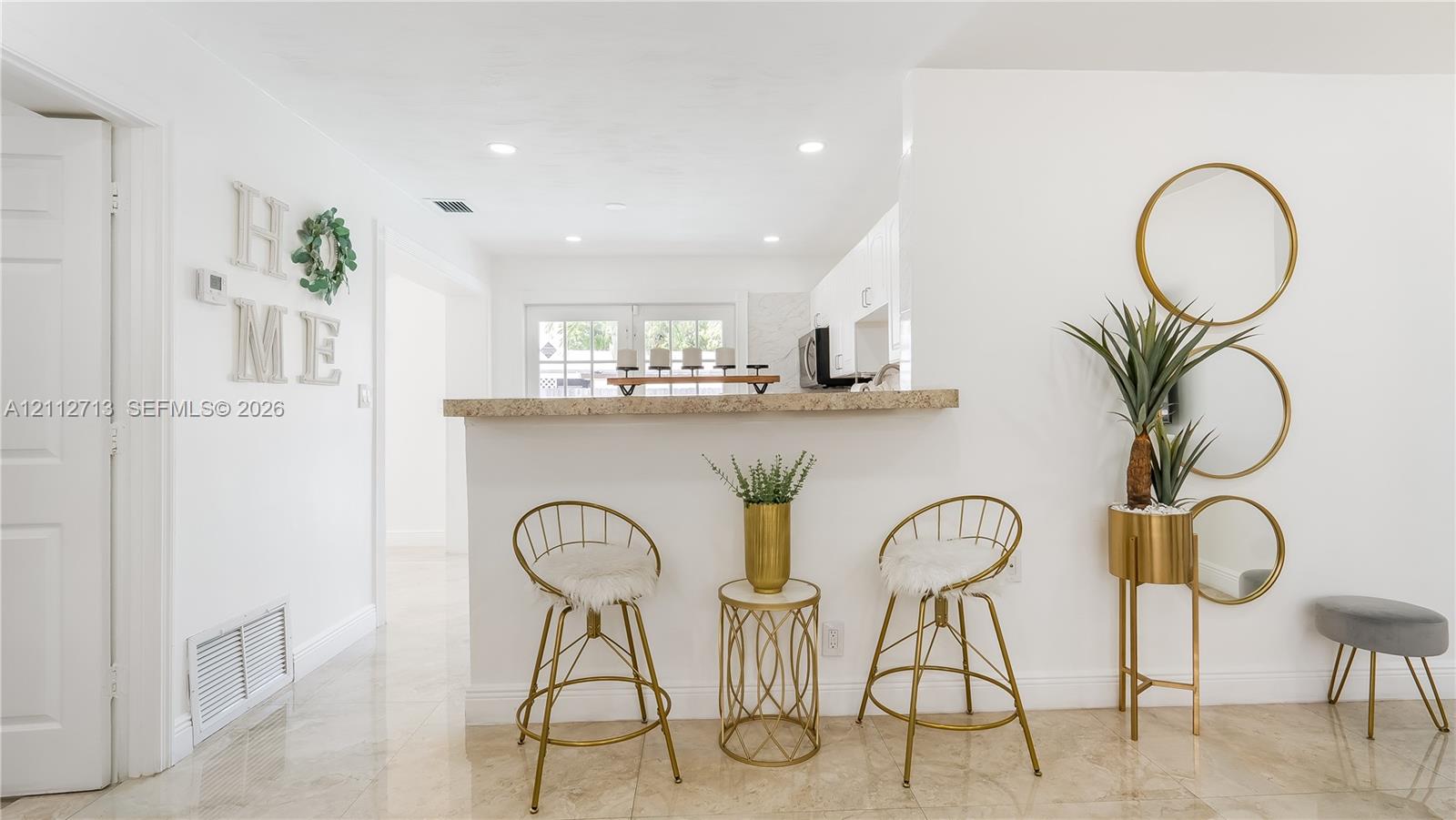 Pass-through service bar with a stone-finish countertop and recessed ceiling lighting throughout the interior
