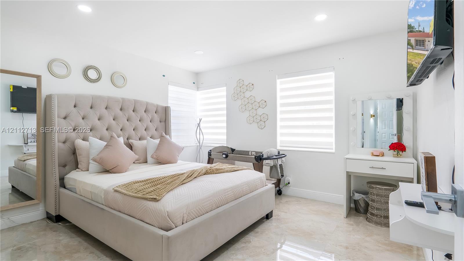 Interior space featuring neutral stone-finish flooring, recessed lighting, and dual-shade window treatments