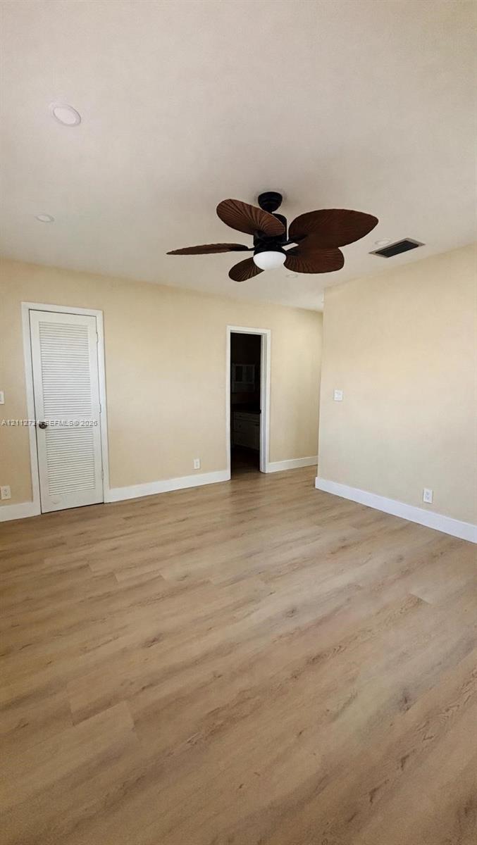 Room featuring wood-finish flooring, recessed lighting, and a multi-blade ceiling fan with an integrated light fixture