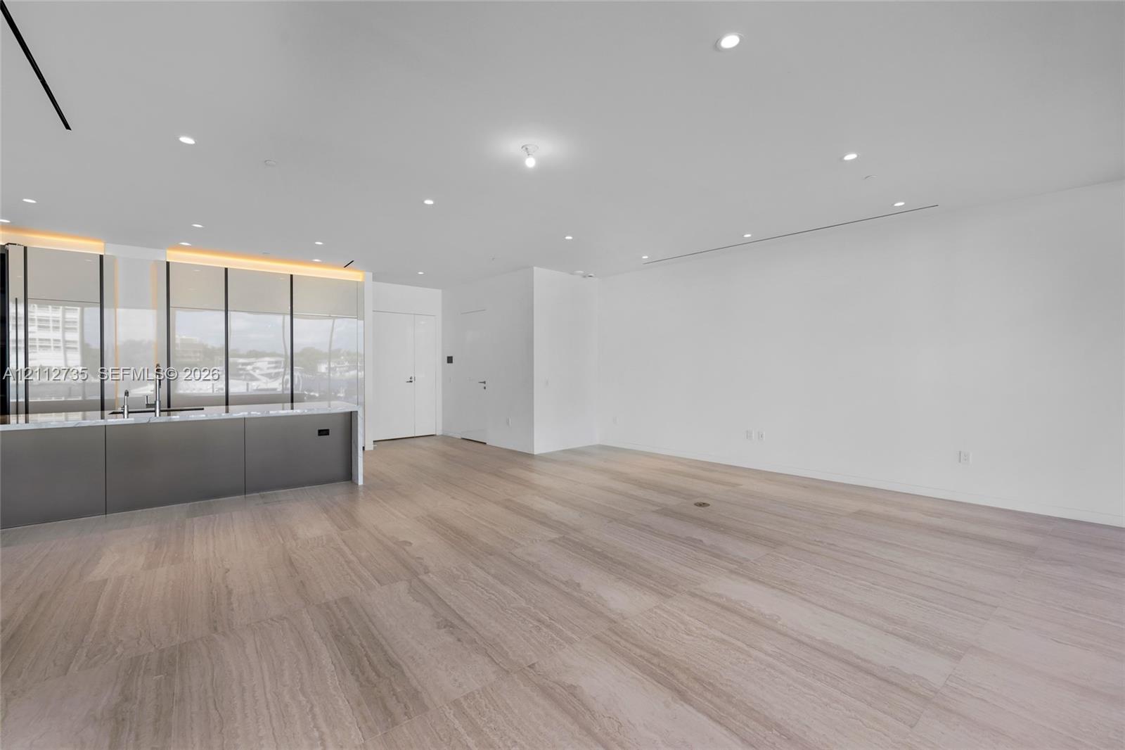 Interior space featuring wood-finish flooring, recessed ceiling lighting, and a kitchen island with stone countertop