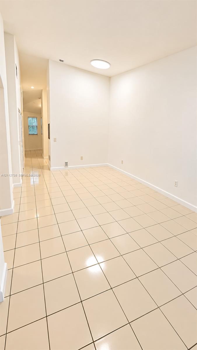 Interior space featuring high vaulted ceilings, neutral wall finishes, and light-toned ceramic tile flooring Interior space featuring high vaulted ceilings, neutral wall finishes, and light-toned ceramic tile flooring