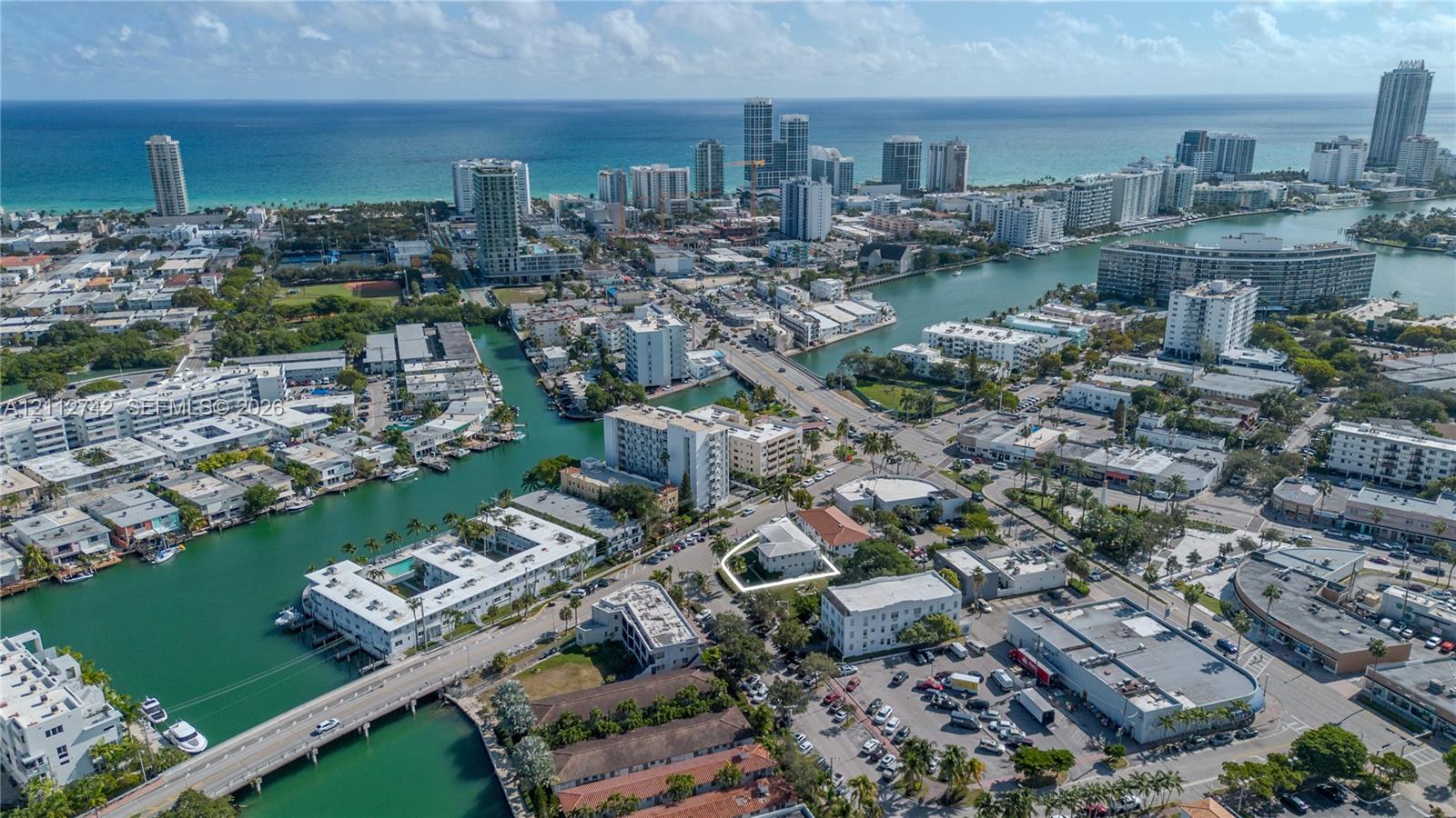 Aerial perspective highlighting a multi-story building located along a coastal waterway in an urban setting