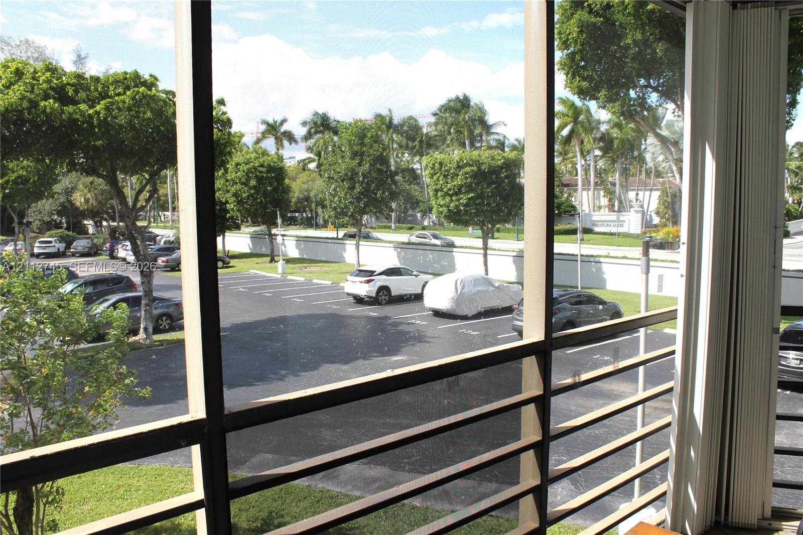 Screened-in outdoor enclosure featuring horizontal metal slats and vertical sliding tracks
