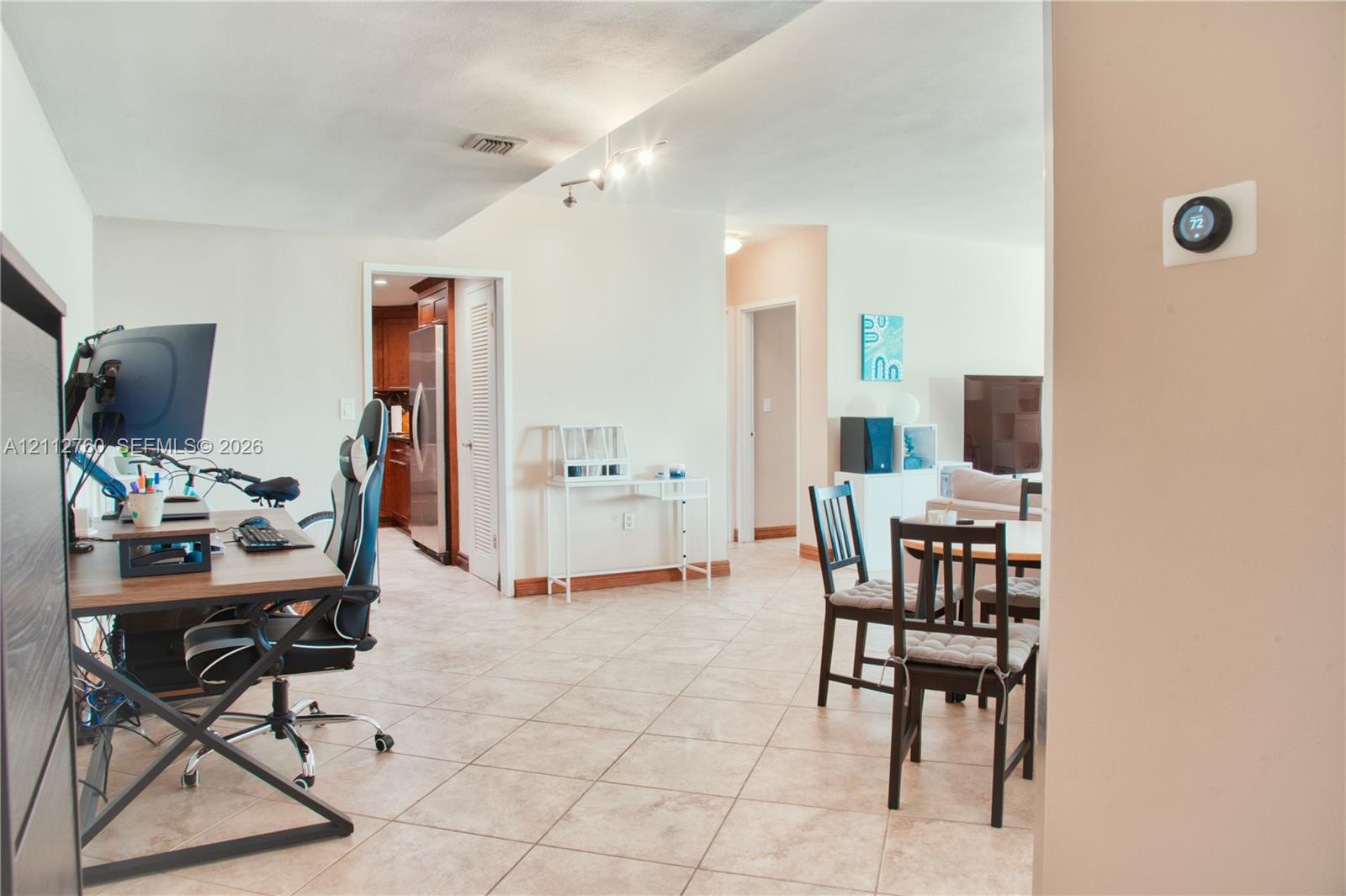 Tile flooring, multi-directional track lighting, and a wall-mounted programmable smart thermostat
