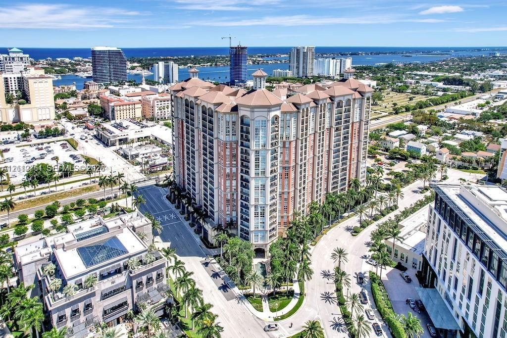 High-rise multi-story building featuring a tile-hipped roof, articulated masonry facade, private recessed balconies, and integrated structural columns