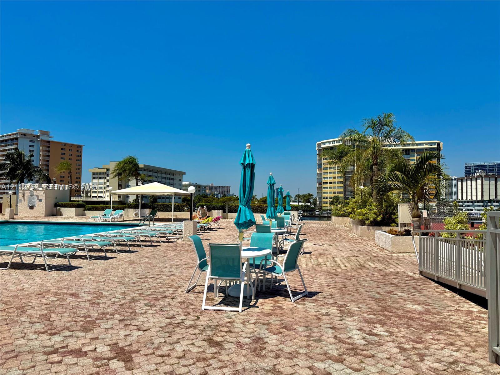 Pool deck featuring concrete paver flooring, a swimming pool, and a shaded pergola structure