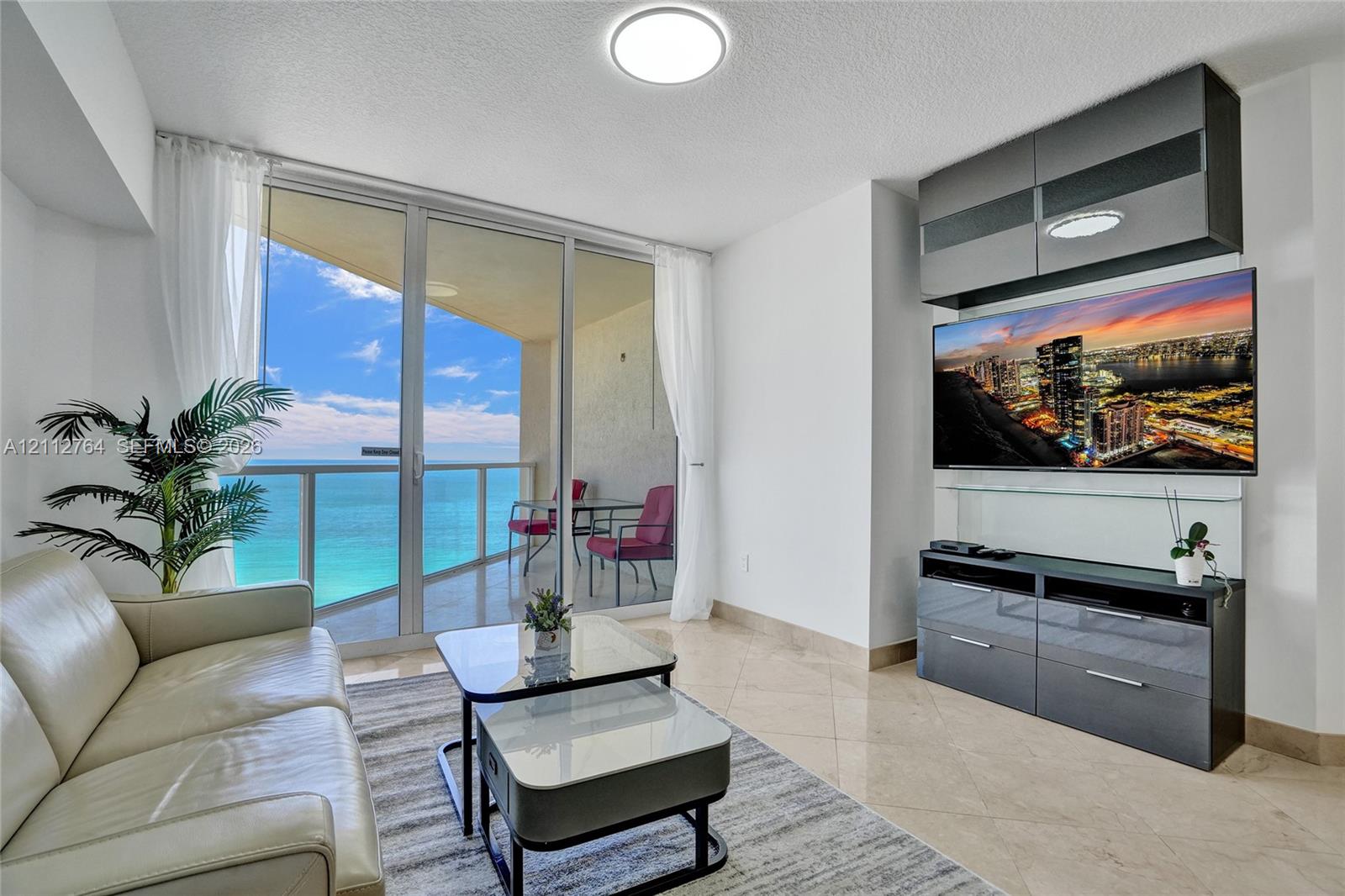 Floor-to-ceiling glass doors, expansive private balcony, polished stone flooring, and built-in high-gloss cabinetry Floor-to-ceiling glass doors, expansive private balcony, polished stone flooring, and built-in high-gloss cabinetry