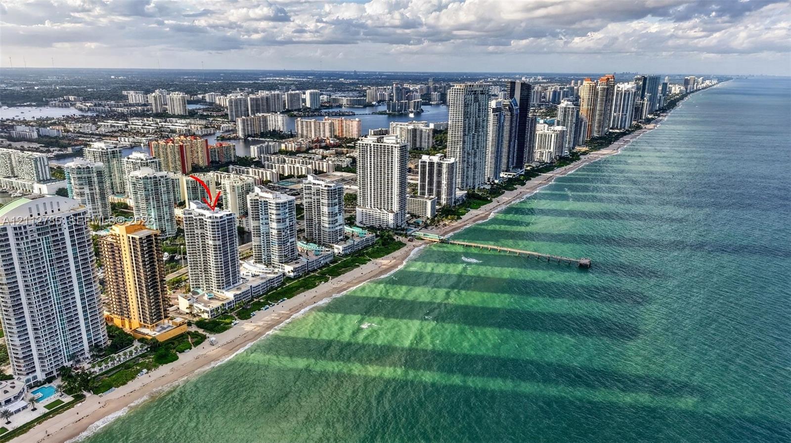 Aerial perspective featuring oceanfront high-rise building with direct proximity to the coastline