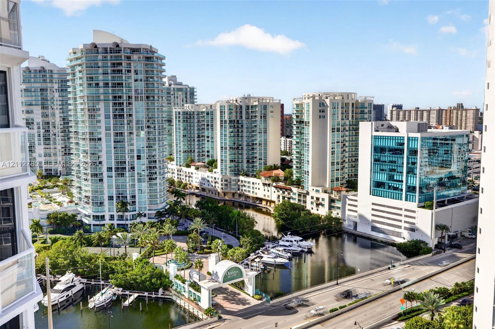 High-rise perspective featuring expansive glass-facade towers, deep-water marina with boat slips, paved multi-level parking structures, and lush tropical landscaping