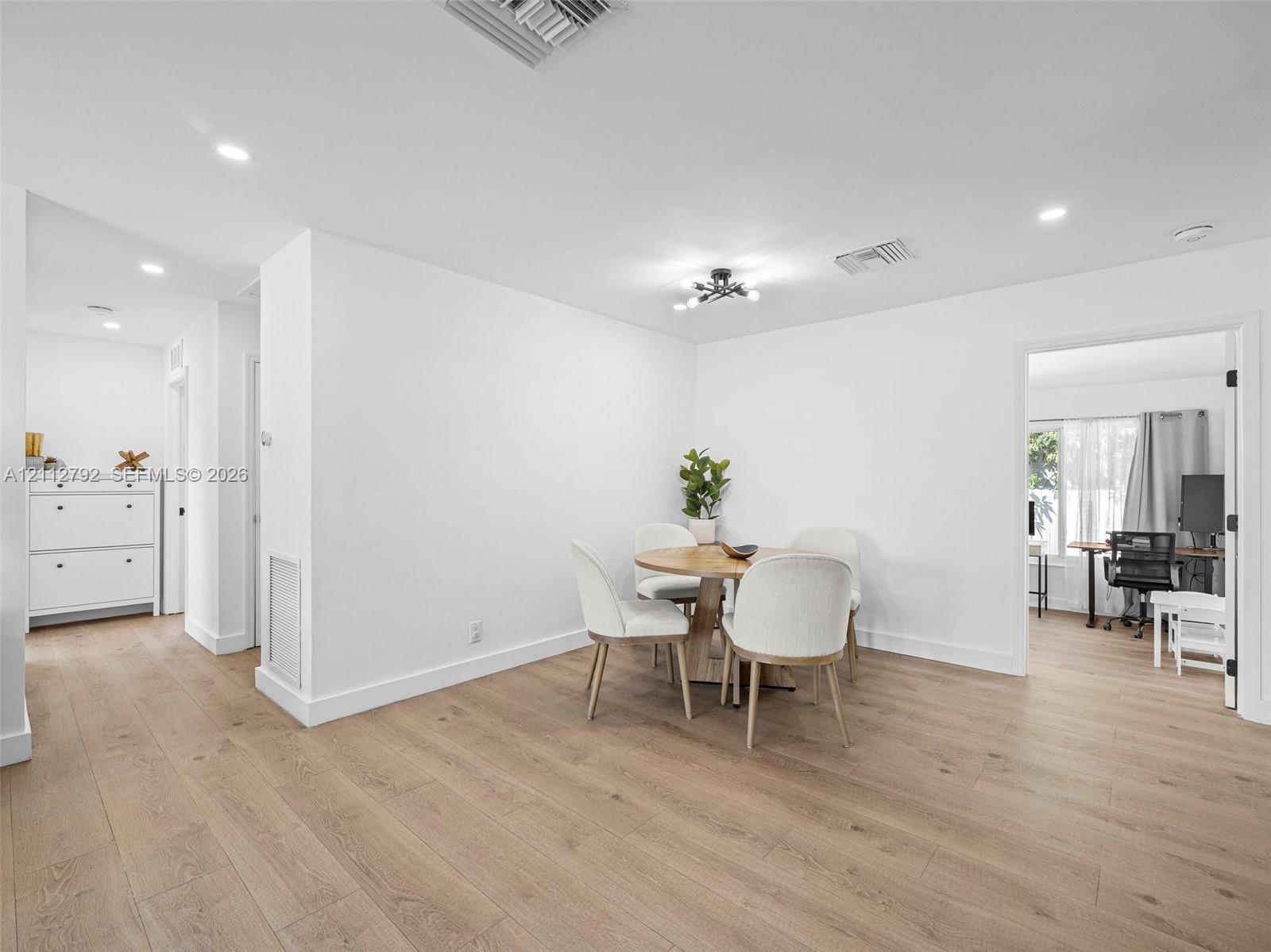 Open floor plan featuring wood-finish flooring, recessed lighting, and a multi-arm modern ceiling fixture