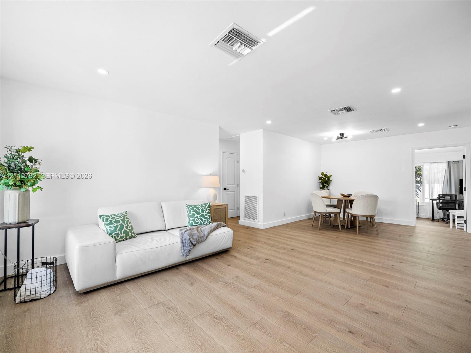 Open-concept interior featuring light-toned wood-finish flooring, recessed lighting, and neutral wall tones