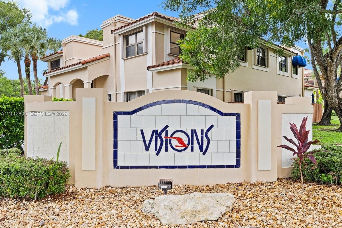 Stucco exterior facade with multi-level rooflines, tile roof accents, and landscaped grounds