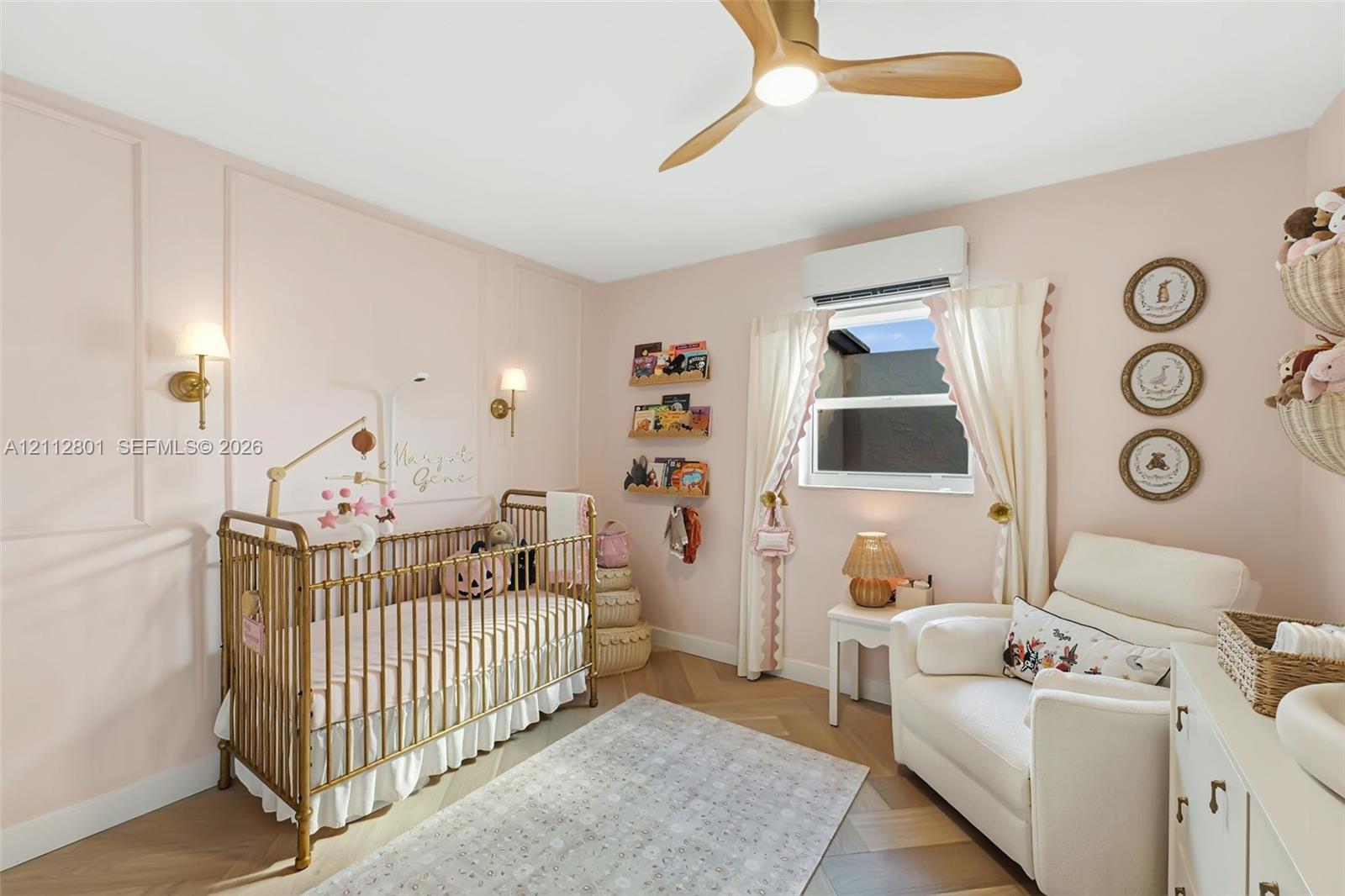 Wall molding accents, wood-finish flooring, wall-mounted light fixtures, ceiling fan with light, and wall-mounted climate control unit