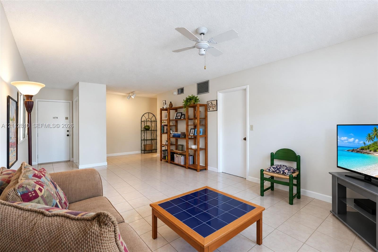 Open floor plan featuring neutral-tone ceramic tile flooring, ceiling fan, and crisp white walls Open floor plan featuring neutral-tone ceramic tile flooring, ceiling fan, and crisp white walls