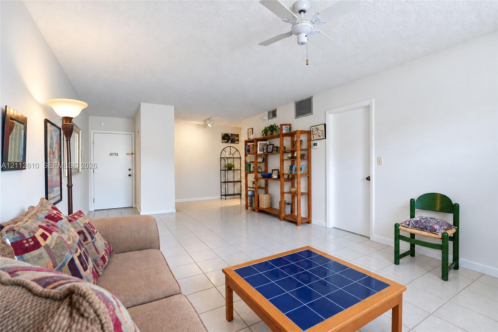 Interior space featuring neutral wall tones, large-format tile flooring, a white ceiling fan, and track lighting Interior space featuring neutral wall tones, large-format tile flooring, a white ceiling fan, and track lighting